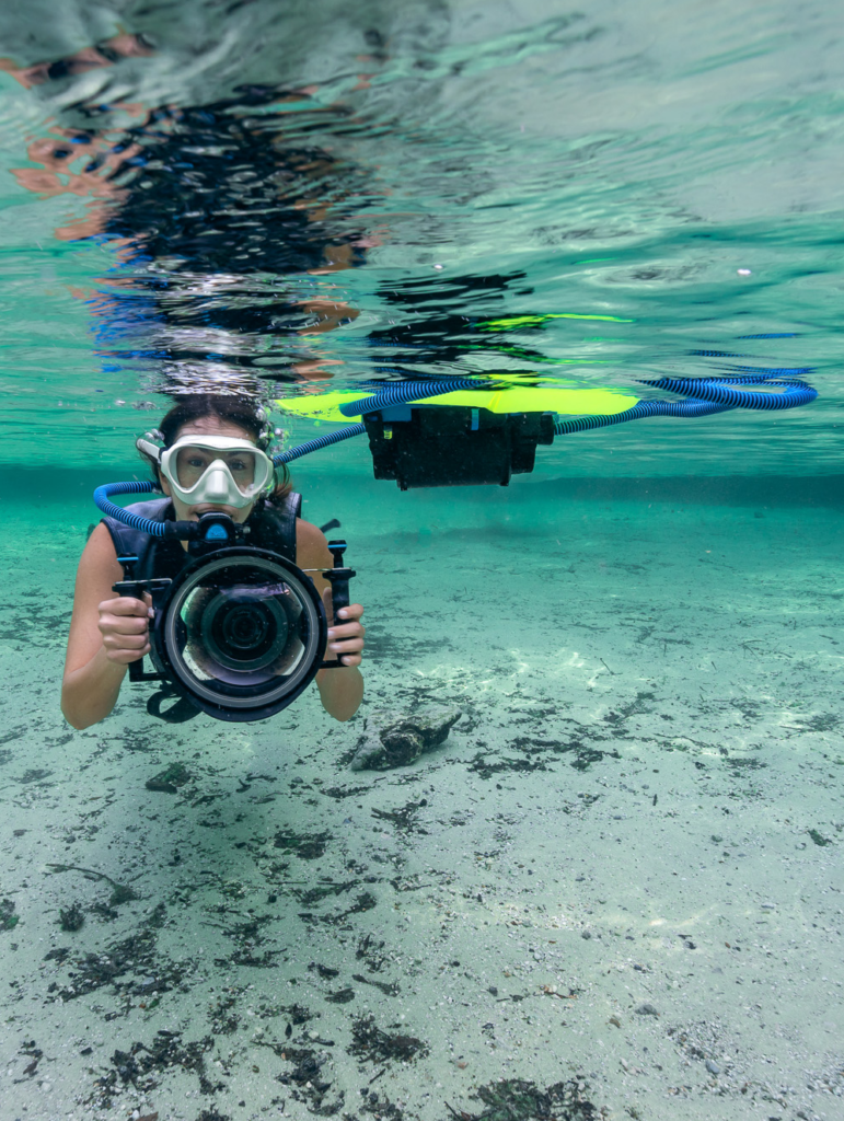 Kimber of Water Bear Photography in clear spring waters, supported by the BLU3 dive system while photographing.