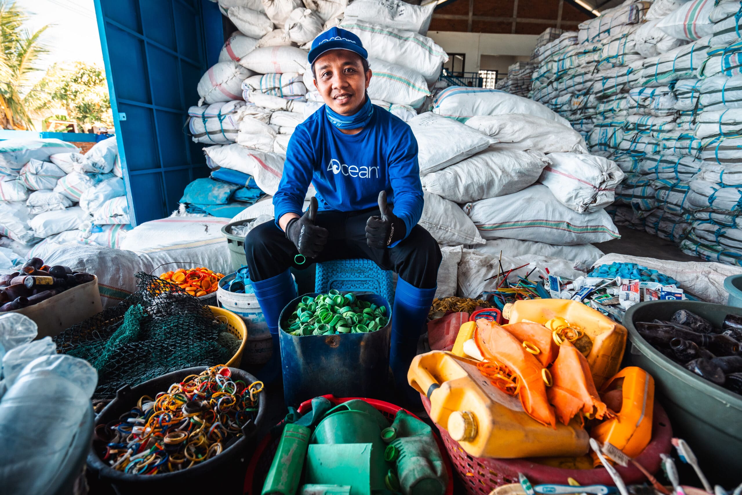 4ocean crew member sorting recovered plastic materials at cleanup facility