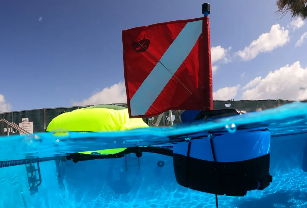 Portable dive system BLU3 Nomad Mini floating in a swimming pool during a leak detection service so technician can breathe underwater without scuba gear.