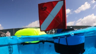 Portable dive system BLU3 Nomad Mini floating in a swimming pool during a leak detection service so technician can breathe underwater without scuba gear.