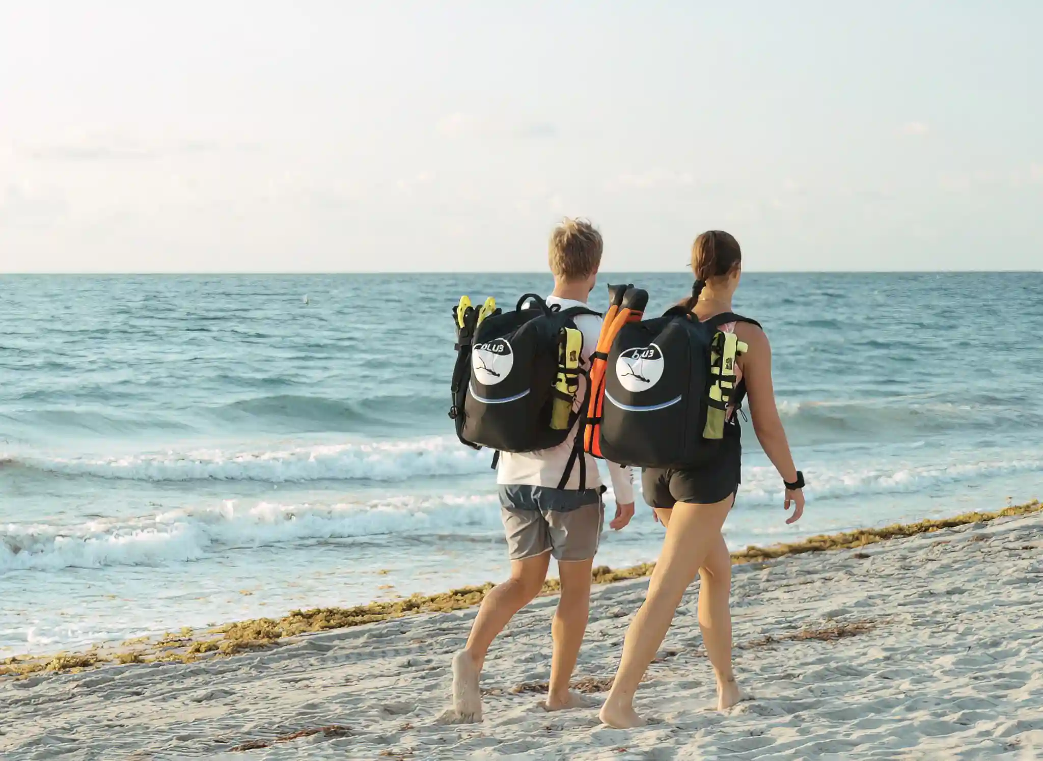 Two people at the beach wearing BLU3 Backpacks